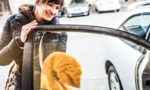 woman cleaning window to prevent Houston auto glass repair